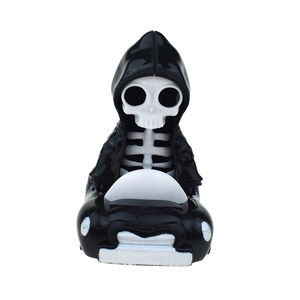 Macro detail of Halloween skeleton ghost figure driving a black pull-back car toy
