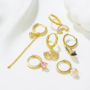 Set of six gold drop earrings featuring heart charms, pearls, and high heel charms