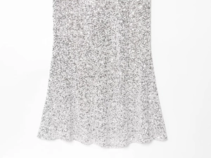 Détail des paillettes argentées scintillantes sur le tissu d'une robe de soirée sexy