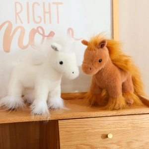 Cute plush horse dolls in white and brown colors on wooden cabinet home decor