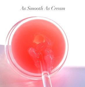 Texture shot of pink lip scrub in a glass jar with a clear spatula as smooth as cream