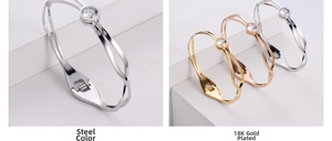 Close-up of streamlined titanium steel bangles featuring an inset round cubic zirconia stone