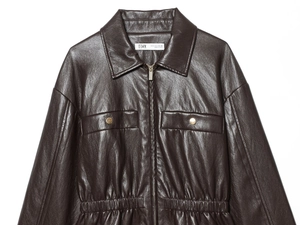 Detail einer dunkelbraunen Kunstlederjacke mit Metallreißverschlüssen und Textur