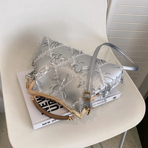 Detailed shot of a silver sequined evening clutch bag with fringe on a chair