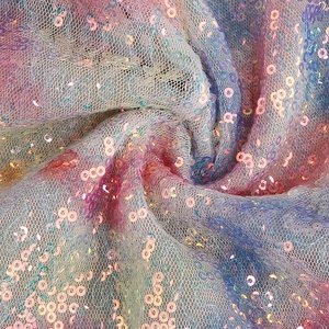 Macro view of gradient sequins on mesh fabric showing iridescent texture and color
