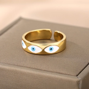 Macro shot of gold enamel evil eye open ring on dark textured jewelry display box