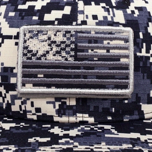 Macro view of tactical camouflage mesh cap featuring embroidered US flag patch
