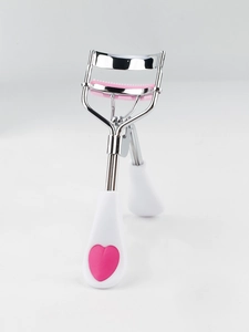 Close-up of stainless steel eyelash curler with pink silicone pad and heart detail