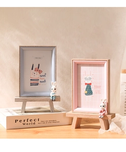 Detail of wooden cartoon bunny photo frames with miniature bench stands in soft pastel colors