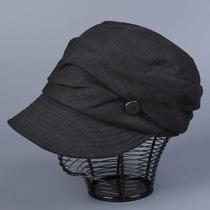 Close-up of black breathable linen peaked cap featuring pleated texture and side button