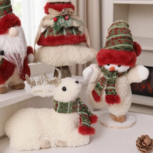 Dettaglio di statuette natalizie in peluche con sciarpe di maglia e corna luccicanti