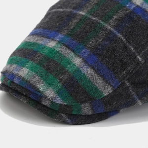 Close-up of wool plaid ivy cap featuring soft texture in grey, green and blue patterns