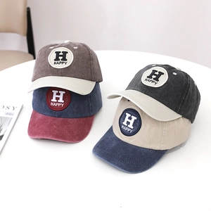 Detail of washed cotton kids baseball caps with vintage texture and Happy embroidery