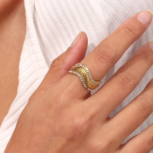 Macro detail of 18K gold-plated chevron ring with zircon stones on model's finger