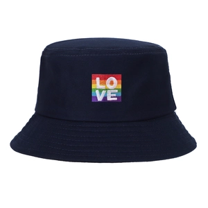Detailaufnahme des Regenbogen-LOVE-Sticks auf dem dunkelblauen Fischerhut aus Baumwolle