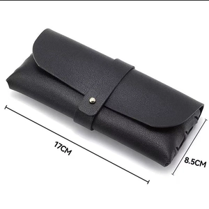 Detailed view of black pebbled leather sunglasses case with button strap 17x8.5cm