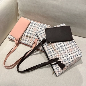 Pink and brown checkered tote bags with matching small pouches on a beige sofa
