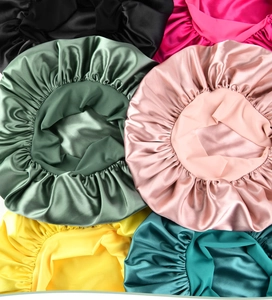 Macro shot showing diverse colors of silky satin sleep bonnets with smooth texture
