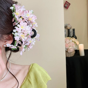 Close-up of pink fabric floral hair claw clip worn on model hair with elegant garden style