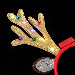 Close-up of LED glowing reindeer headband with gold glitter antlers and colorful metal bells