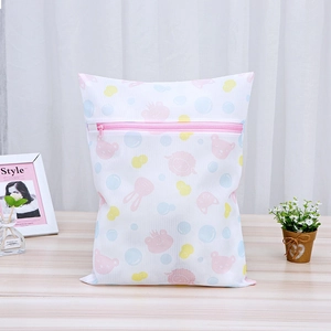 Close-up of mesh laundry bag with rabbit prints and pink zipper on a wooden table