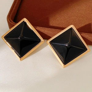 Detail of geometric square stud earrings featuring 3D black resin in gold metal frames