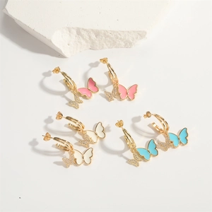 Detailed close-up of bow drop earrings in pink, white, and blue colors with rhinestones