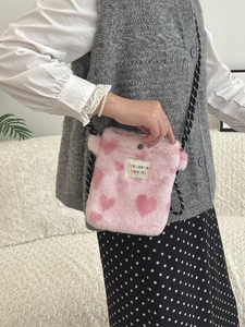 Pink plush mini crossbody bag with heart pattern and black and white drawstring strap