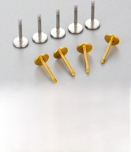 Detailed macro view of titanium steel flat back ear studs in gold and silver finishes
