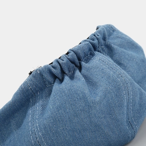 Detailed close-up of blue denim octagonal hat showing elastic pleated edges and fine stitching