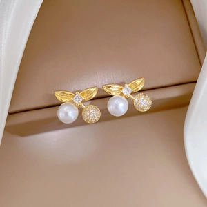 Detailed close-up of cherry earrings with white pearls and sparkling zircon accents