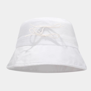 Detail view of a white cotton bucket hat featuring a delicate ribbon bow decoration