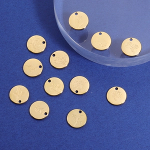 Macro view of gold-plated circular flower pendants on a blue background