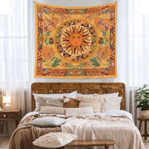 Detail of bohemian sun tapestry hanging above a bed with zodiac symbols and warm tones