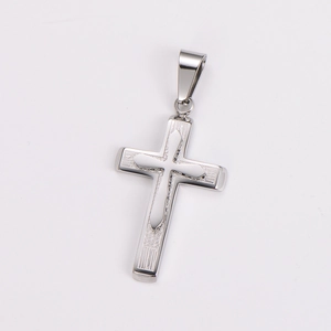 Macro shot of silver stainless steel cross pendant with detailed carved geometric patterns
