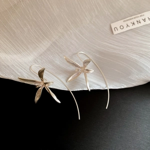 Artistic close-up of elegant silver iris flower drop earrings on a bicolor backdrop