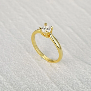 Classic gold S925 silver ring with four-prong set round zircon on a beige textured background