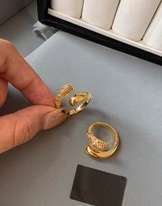 Detail of gold-plated wrap ring featuring drop shape and rainbow zircon pave stones