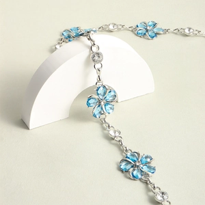 Detailed macro view of silver chain belt featuring blue crystal flowers and rhinestones