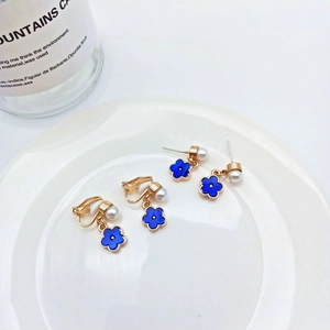 Detail of elegant blue flower earrings with S925 silver needle and white pearl accents