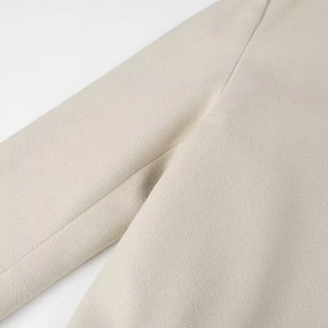 Détail de la texture du tissu en laine beige clair avec des coutures précises