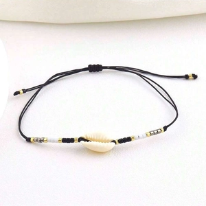 Detailed macro view of the handmade woven cord and natural seashell on the evil eye bracelet