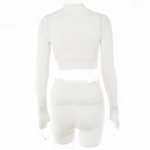 Rear view of white ribbed knit tracksuit showing high waist shorts and a zip-up top