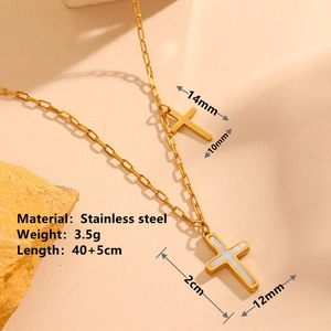 Golden stainless steel double cross necklace with shell inlay on textured stone background