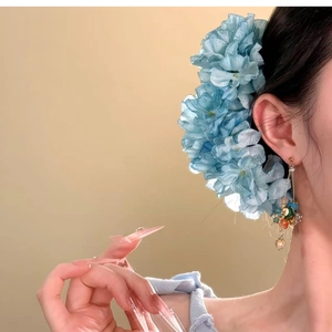 Close-up of elegant blue fabric flower hairpin with multi-layered silk petals