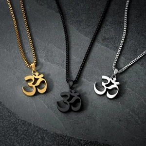 Three Om symbol pendant necklaces in gold, black, and silver steel on stone background