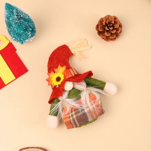 Detail van de oogst kabouterpop met rode vilten hoed, zonnebloem en esdoornblad decor