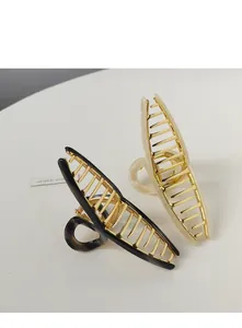 Detail of black and beige resin hair claws with golden metal interior structure