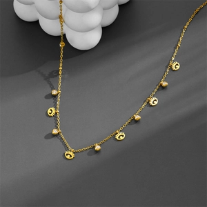 Golden Evil Eye necklace with zircon charms on a textured background in a top-down view