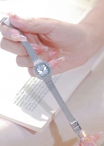 Elegant silver square watch with rhinestone bezel and mesh strap worn by a model